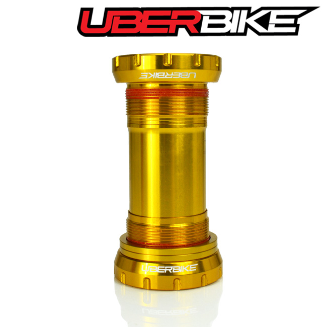 Gold colour SRAM DUB Bottom Bracket stood up with the logo of Uberbike in white.