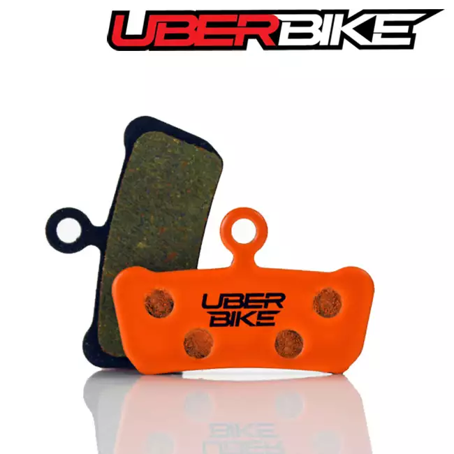 Orange Uberbike Kevlar disc brake pads for SRAM Guide with the Uberbike logo in the middle of them.