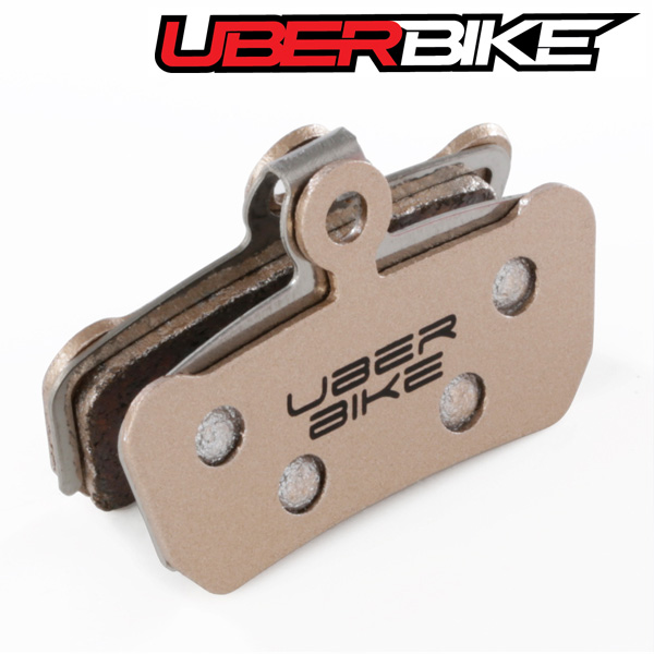 Uberbike Sintered Disc Brake pads in gold colour, with Uberbike logo in middle of them.