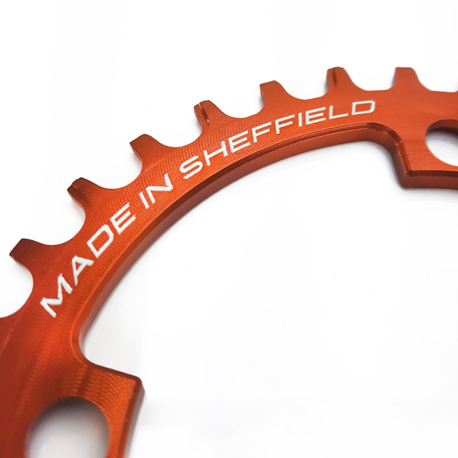 Close up of Uberbike Made in Sheffield orange chainring.