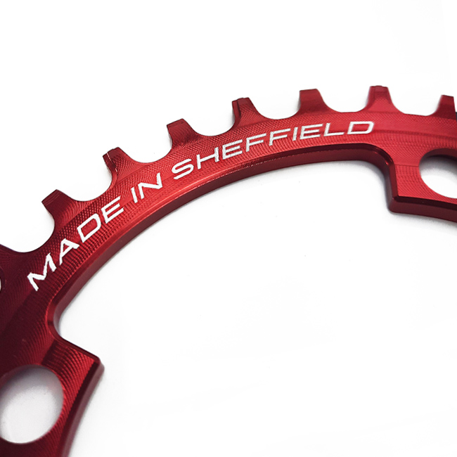 Close up of red Uberbike made in Sheffield chainring.